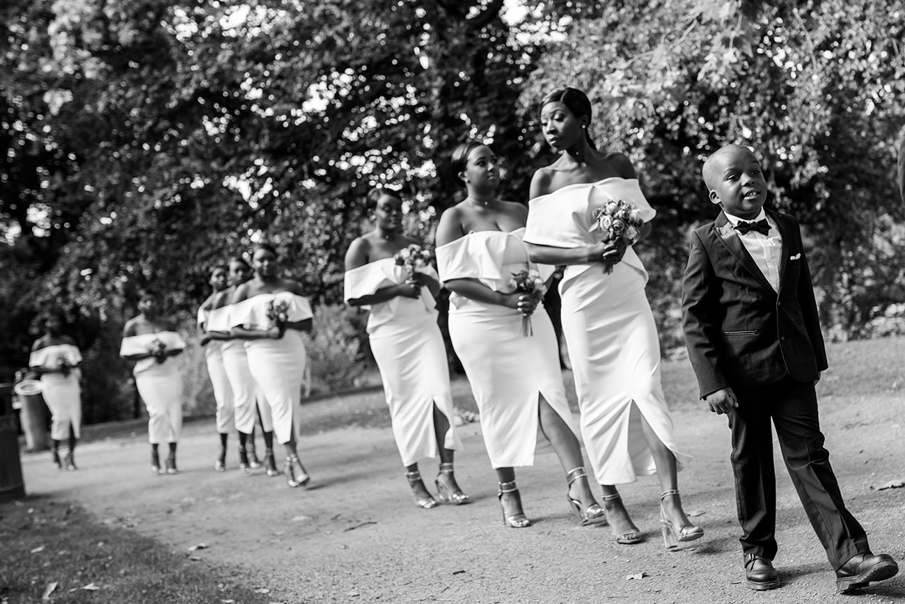 Black and white photograph showing people walking in a park or garden setting.