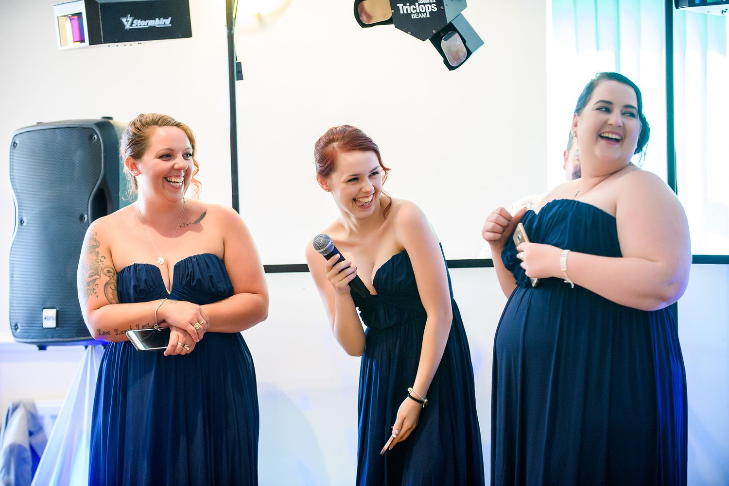 Bridesmaids in navy blue dresses prepare for wedding ceremony.