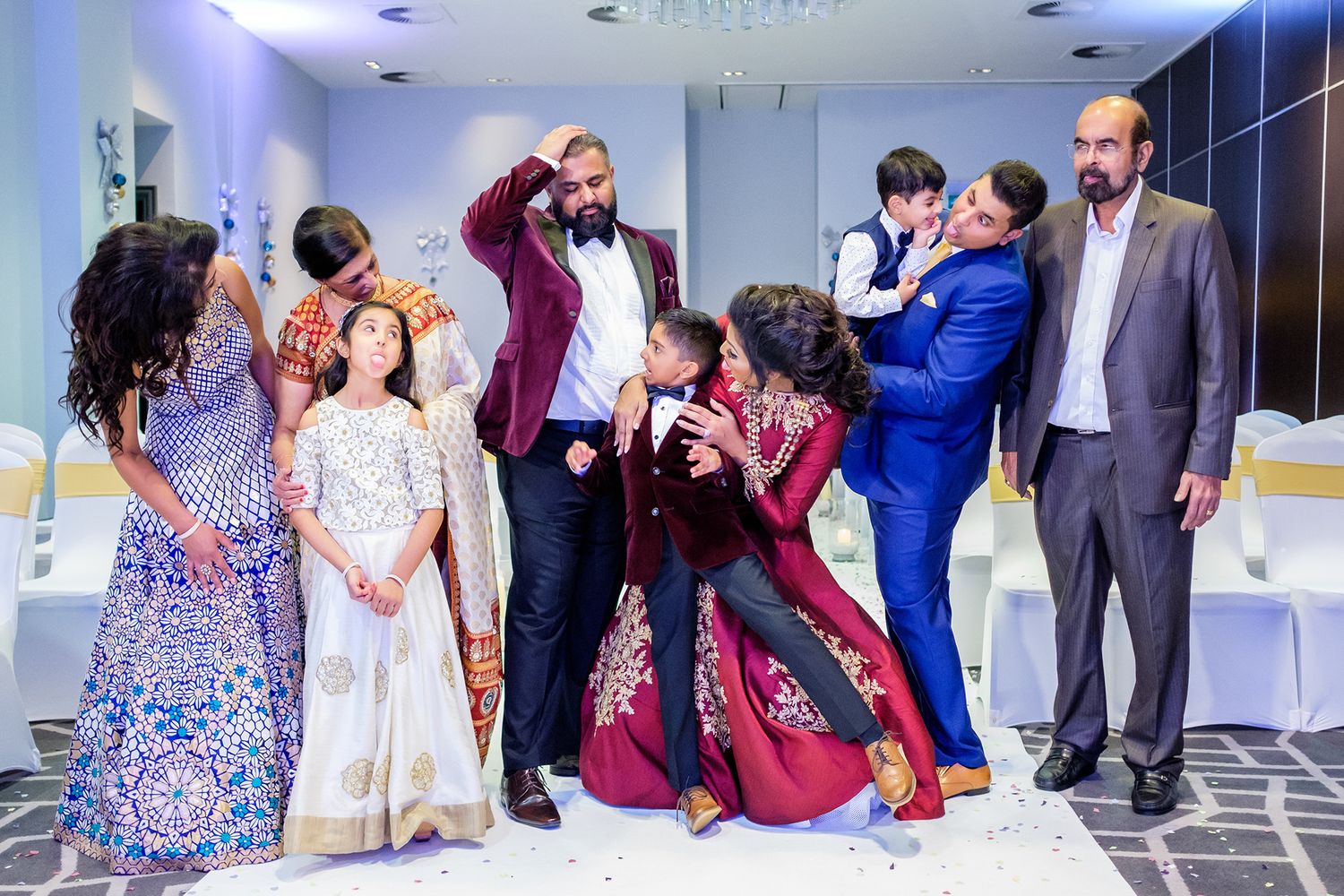 Wedding guests laugh and celebrate together during an indoor reception.