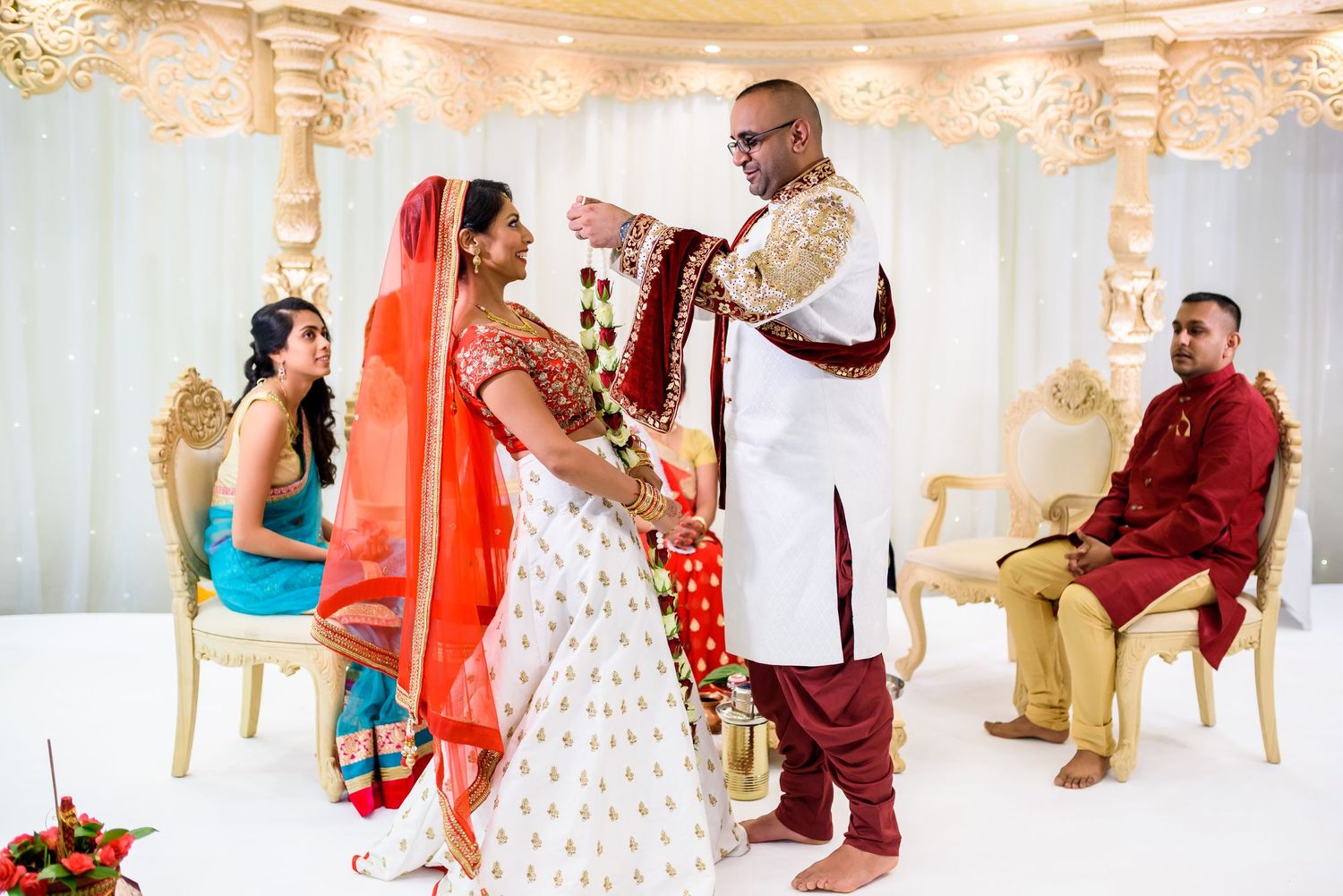 Elegant wedding ceremony moments captured in a luxurious gold and white decorated ballroom setting.