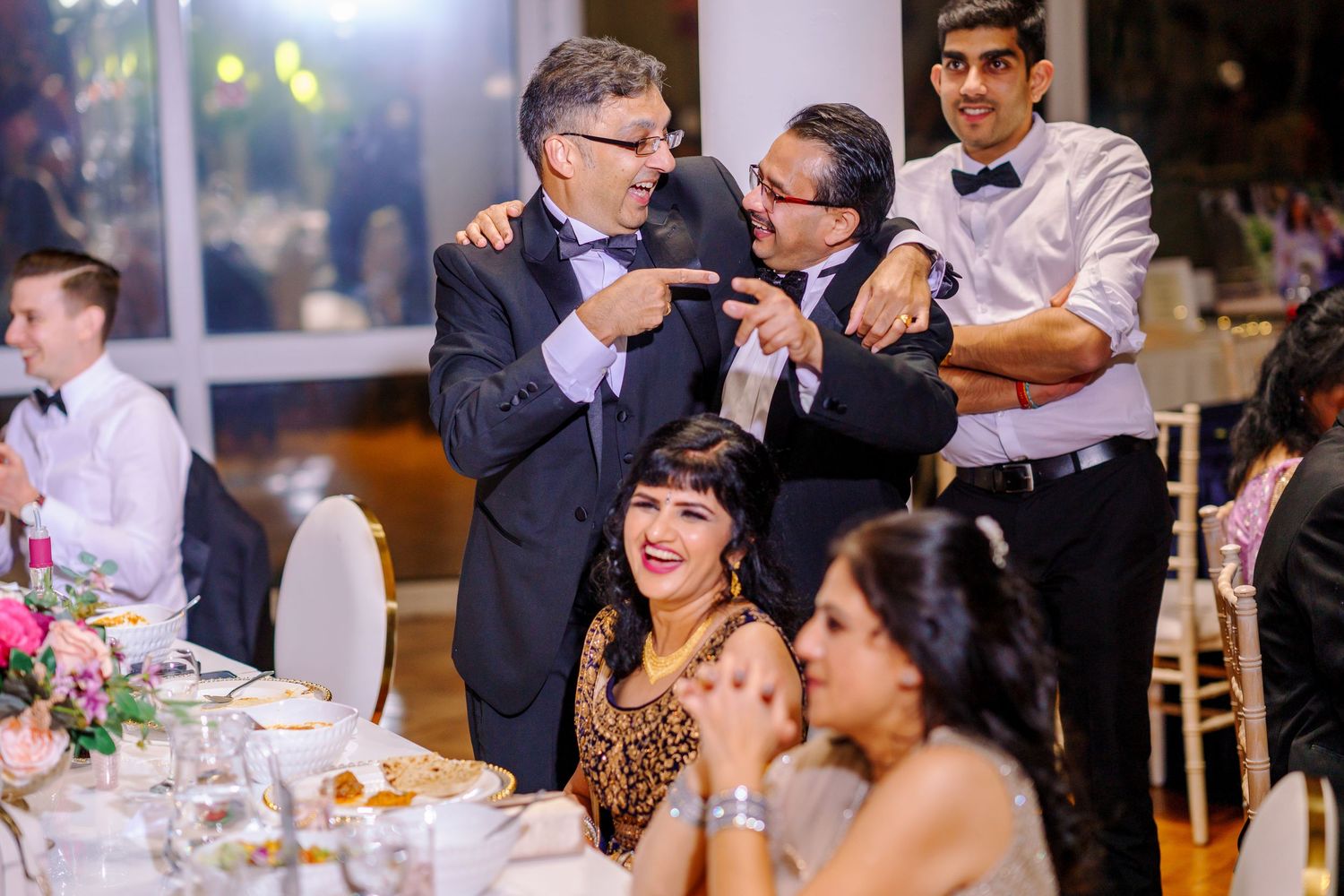 Wedding reception celebration with guests enjoying dinner and entertainment at an elegant venue.