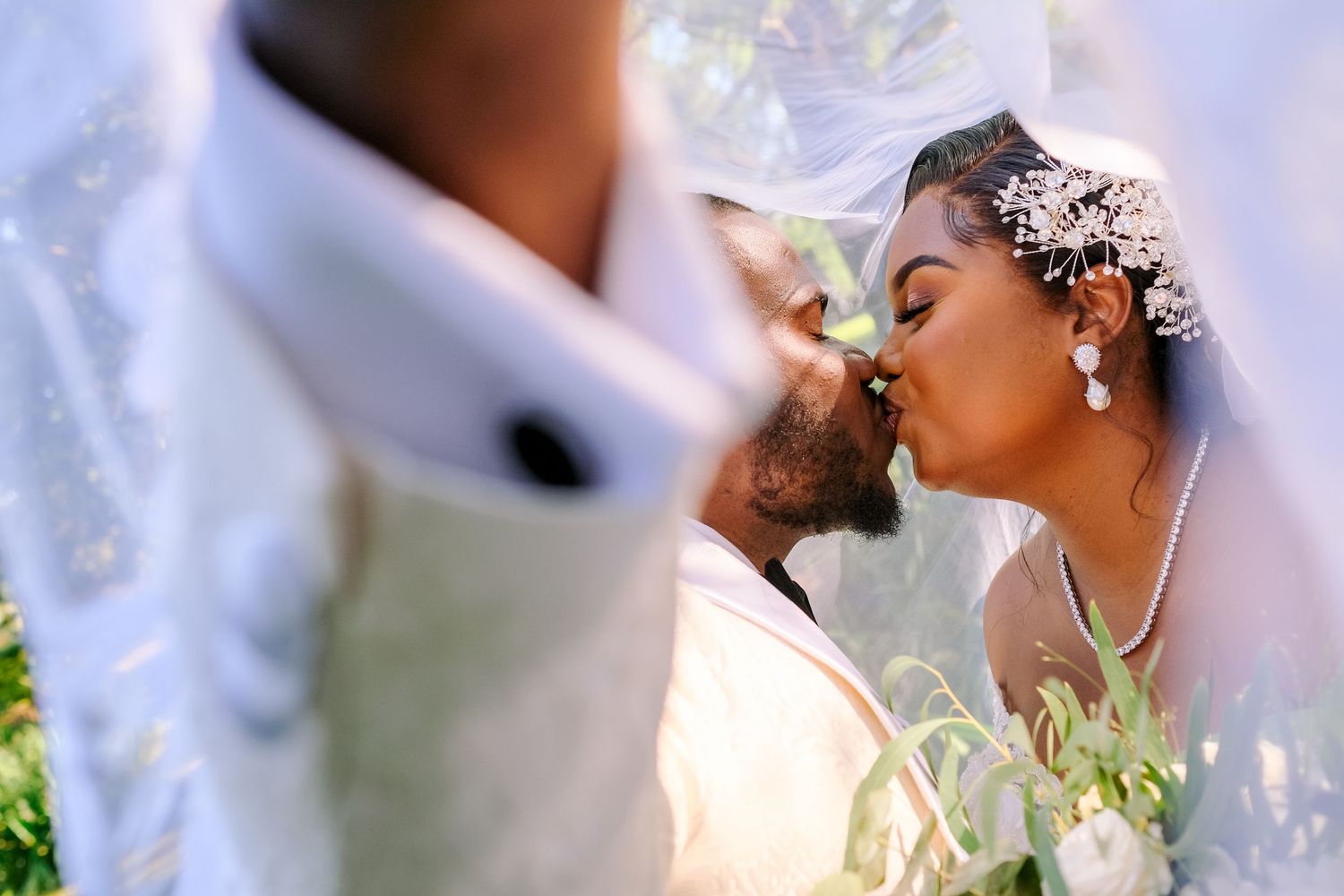 Close-up shot of newlyweds sharing an intimate moment during their outdoor wedding ceremony.