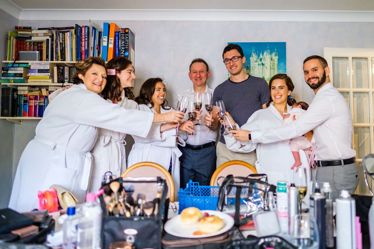 A group of people in chef's whites celebrate in a professional kitchen with drinks and smiles.