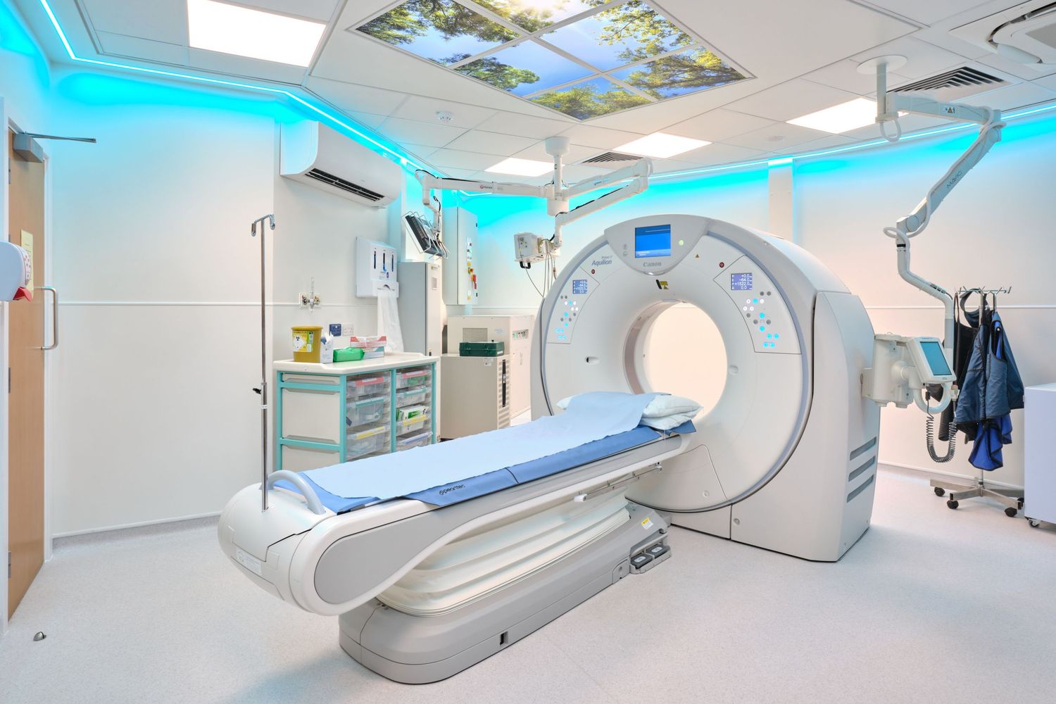 Modern medical imaging facility with CT scanner and advanced diagnostic equipment in clean white room.