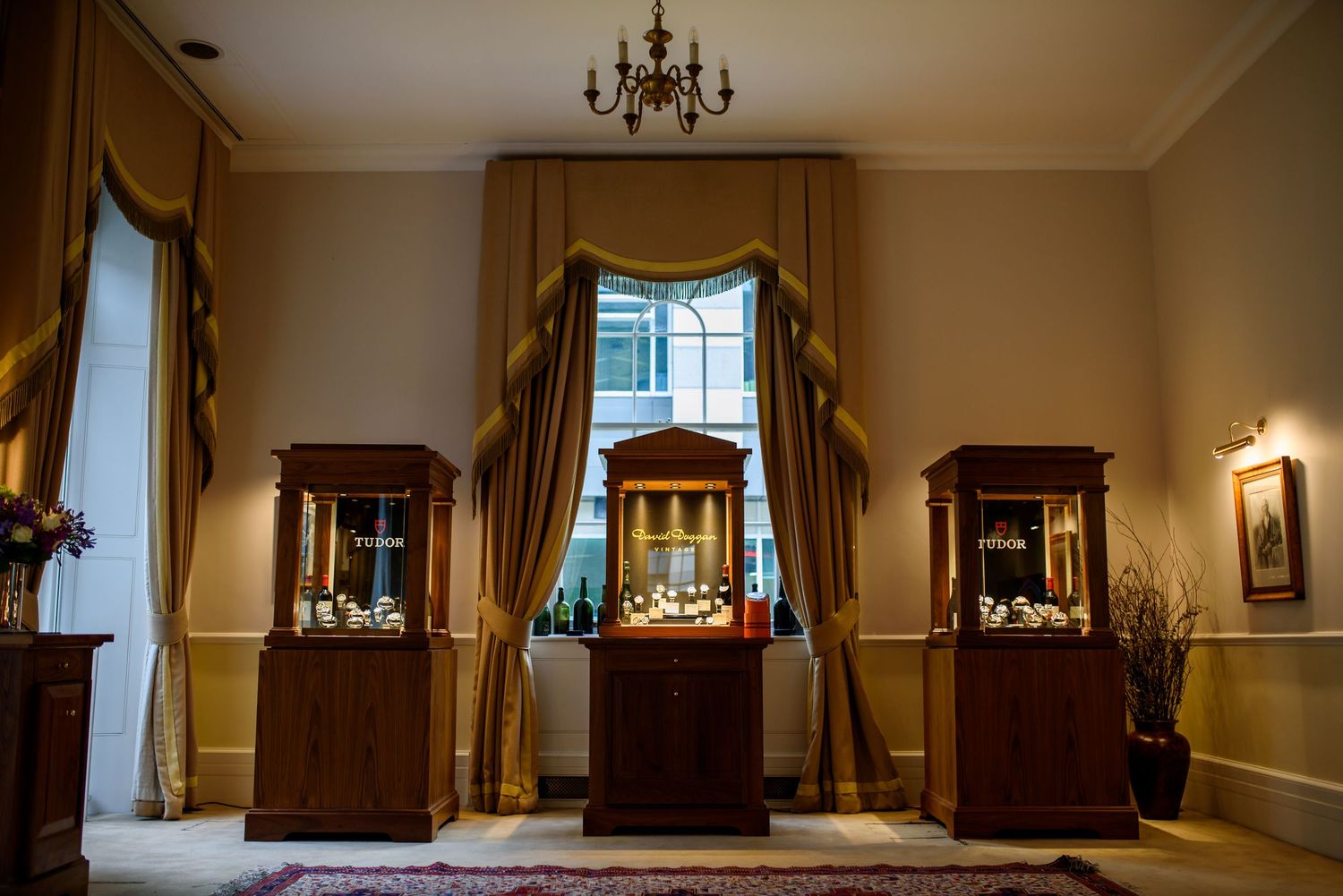 Panoramic view of an elegant meeting room with chandeliers and wooden furniture against cream walls.