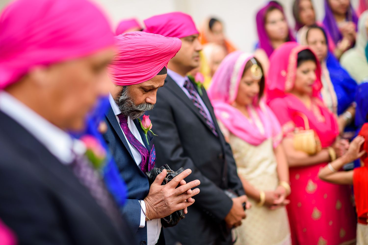 Colorful traditional celebration with guests wearing bright pink and blue attire.