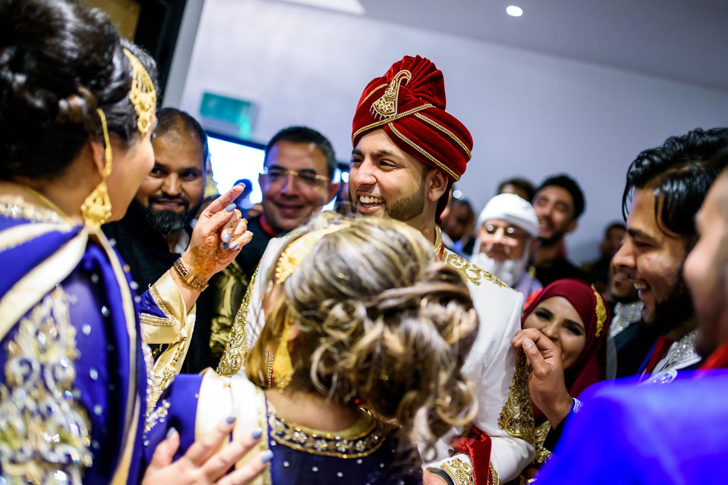 Candid moment of wedding celebration showing guests gathered in formal ethnic wear.