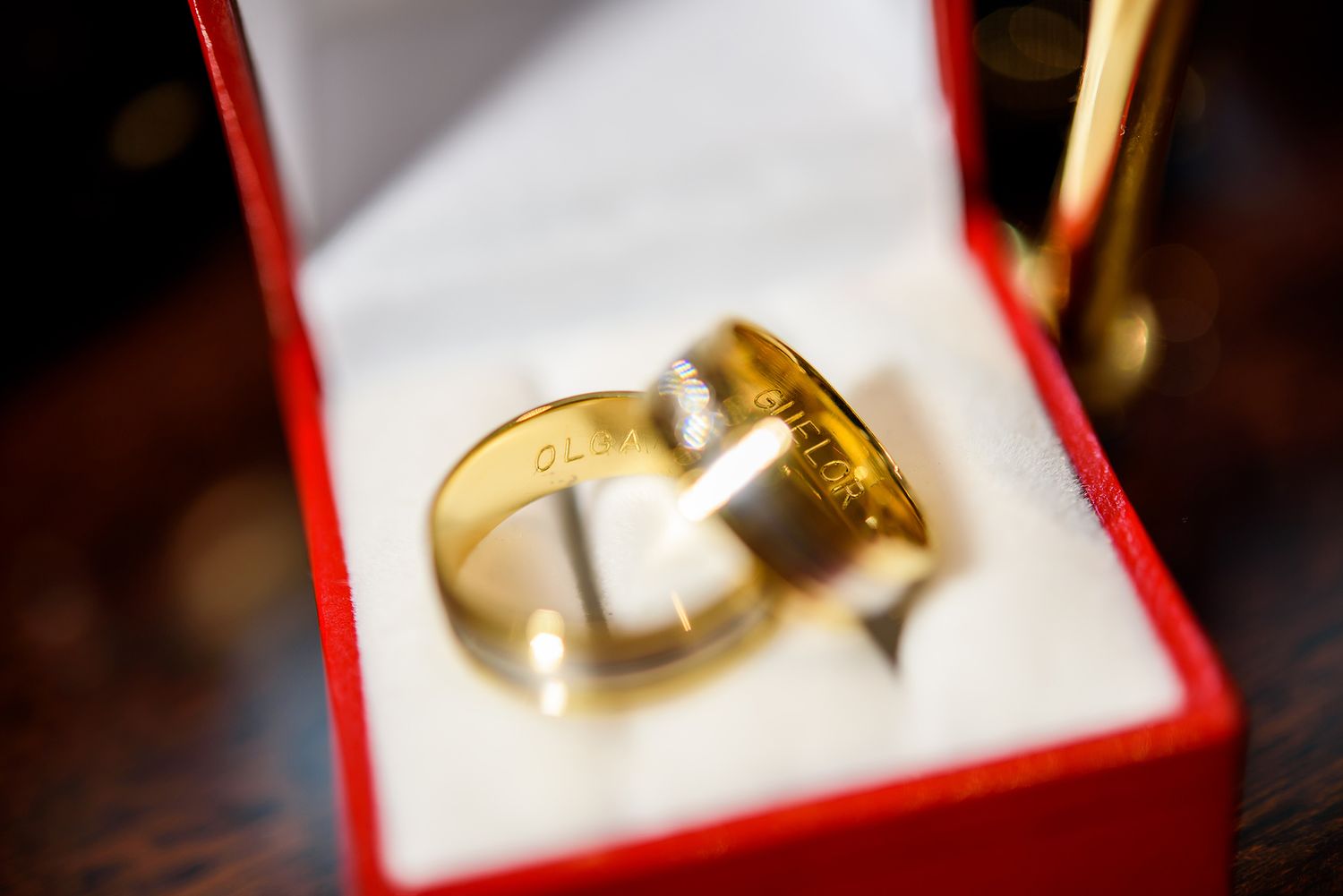 Wedding rings displayed in red jewelry boxes with elegant lighting.