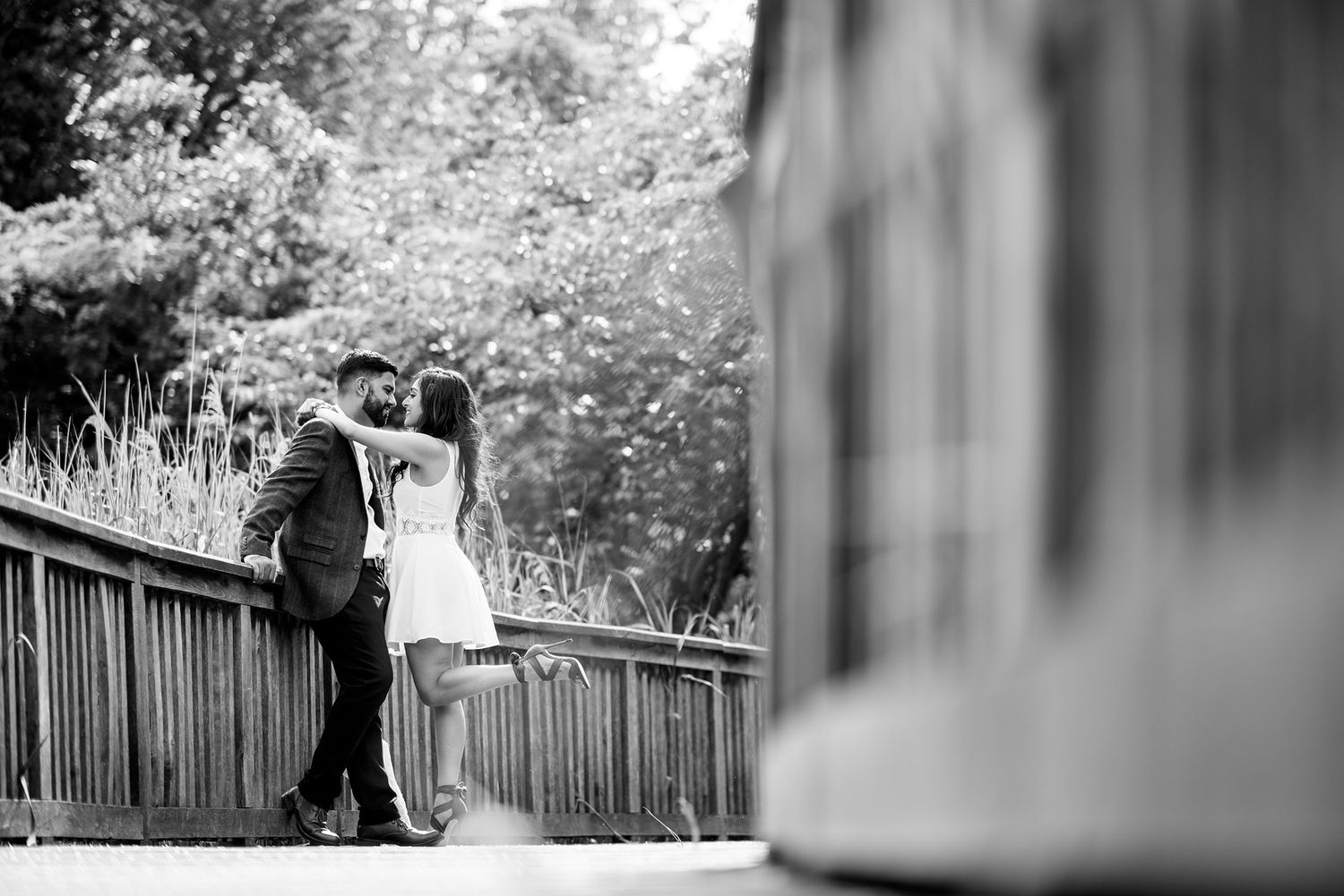 Artistic black and white wedding photograph with natural garden elements.