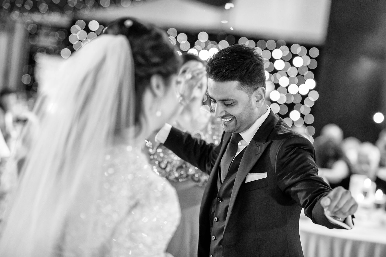 Elegant black and white shot of celebration with sparkling lights and formal attire.