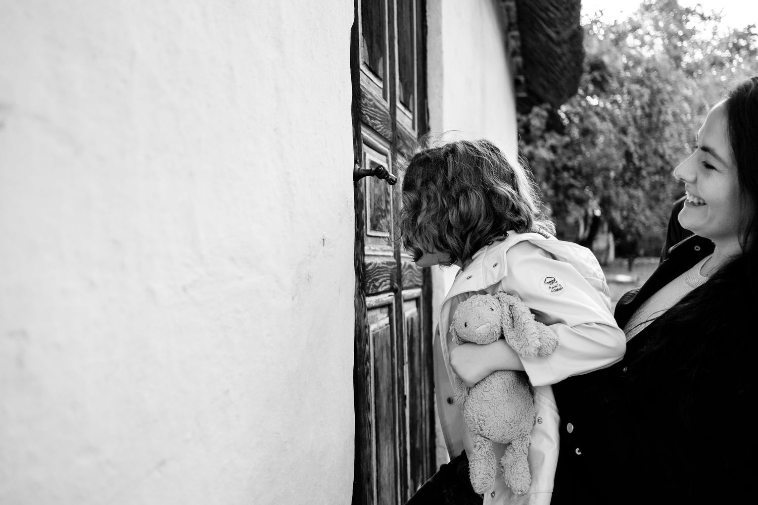 Black and white series capturing intimate family moments indoors.