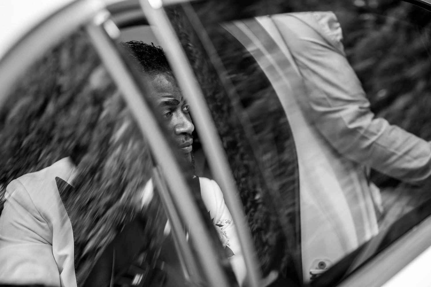 Wedding party entering vehicle through car door in celebratory moment.