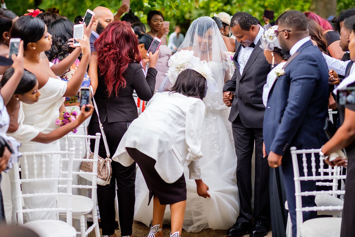 Wedding celebration candid moments with guests in formal attire outdoors.