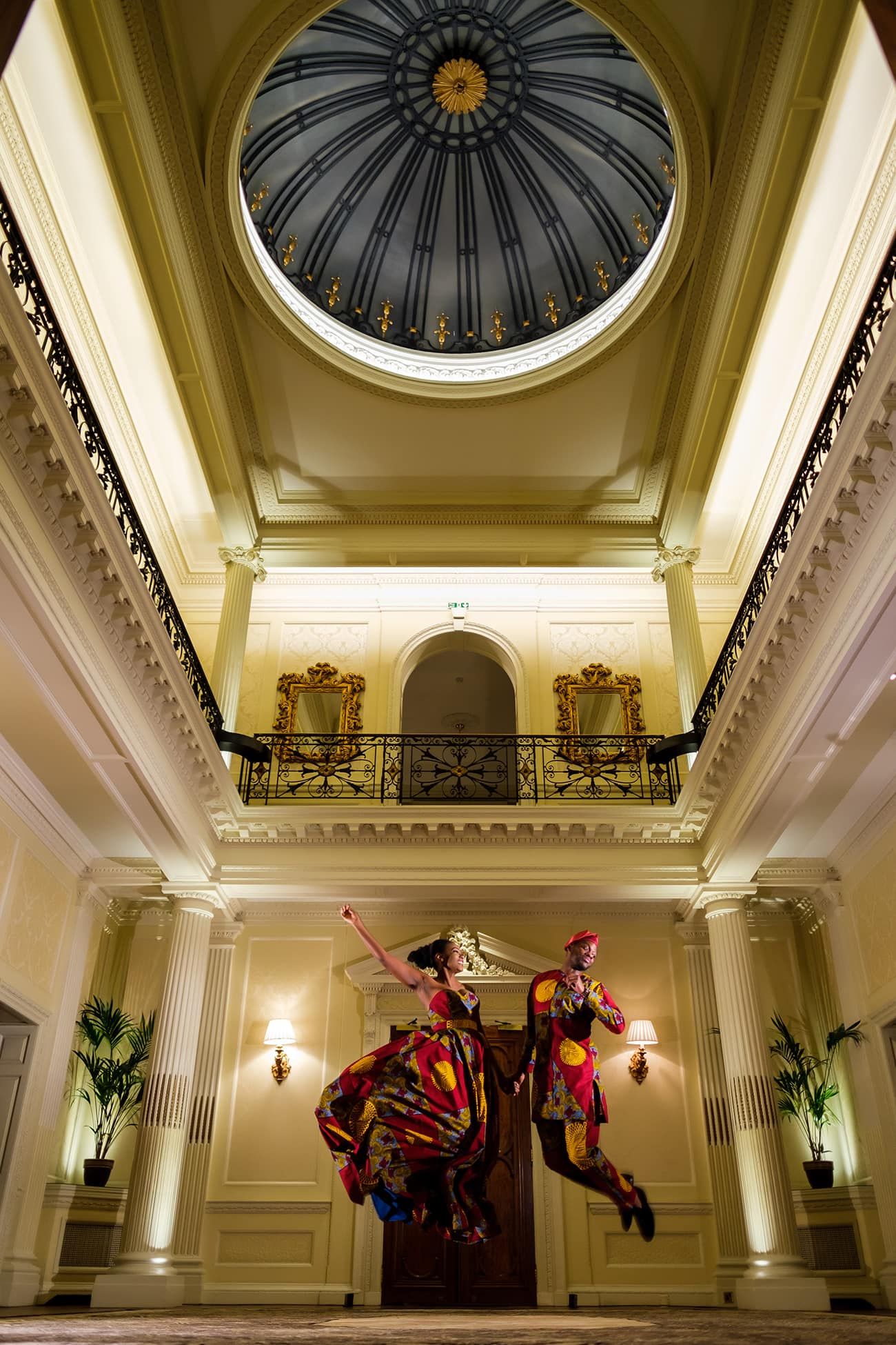 Elegant domed ceiling with ornate details and dramatic lighting in a grand ballroom.