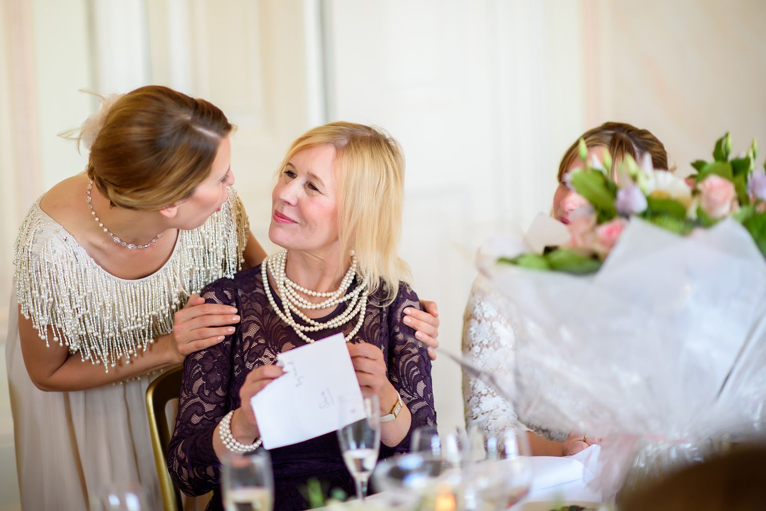 Guests enjoying candid conversations and laughter during wedding celebration at round tables.