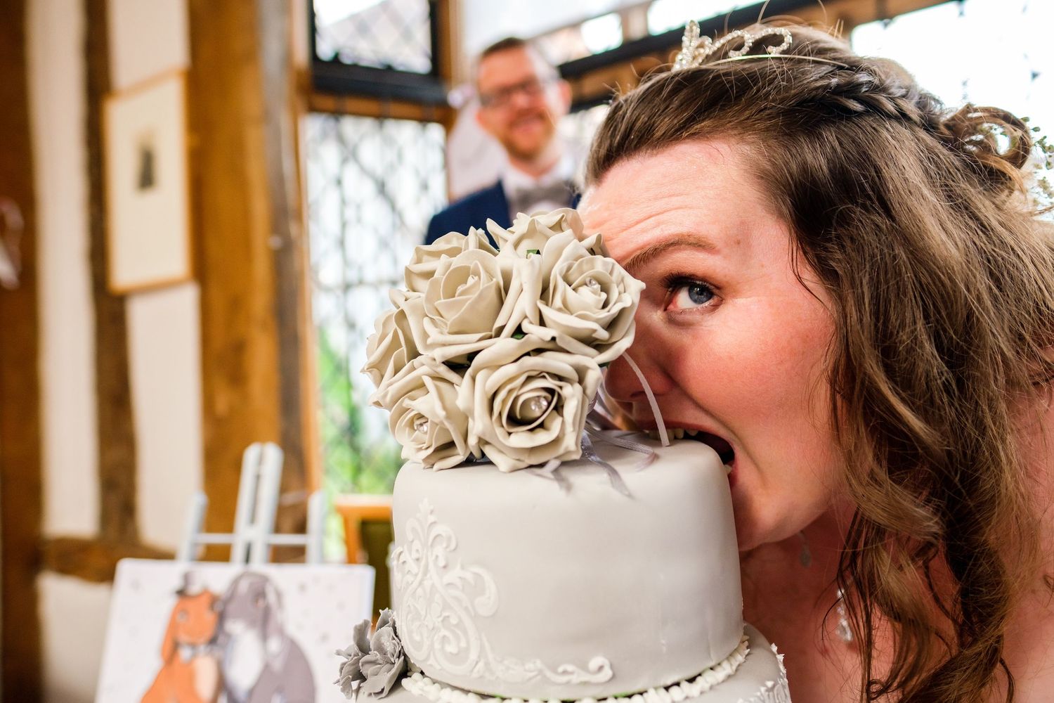 Close-up shot of a white wedding cake with intricate piping details and decorative elements.