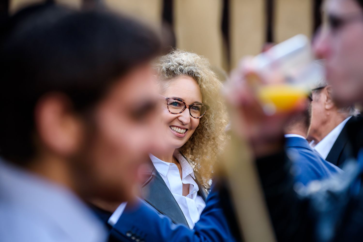 Wedding guests in formal attire socialize during an outdoor reception.