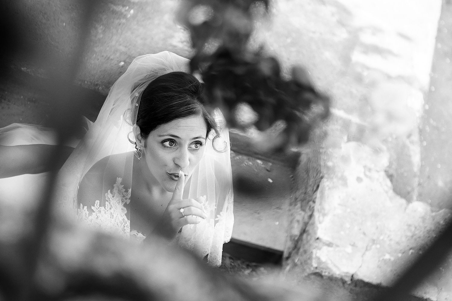 Wedding party and guests pose for black and white photos in an elegant setting.