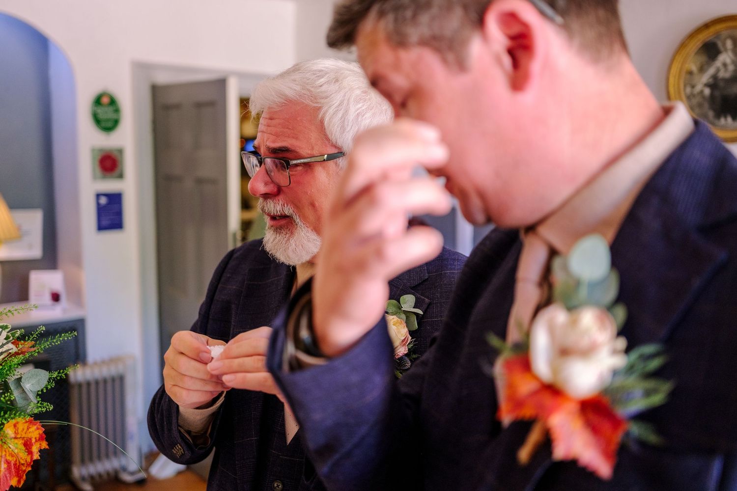 Close-up view of wedding guests engaged in animated conversation at an indoor celebration.