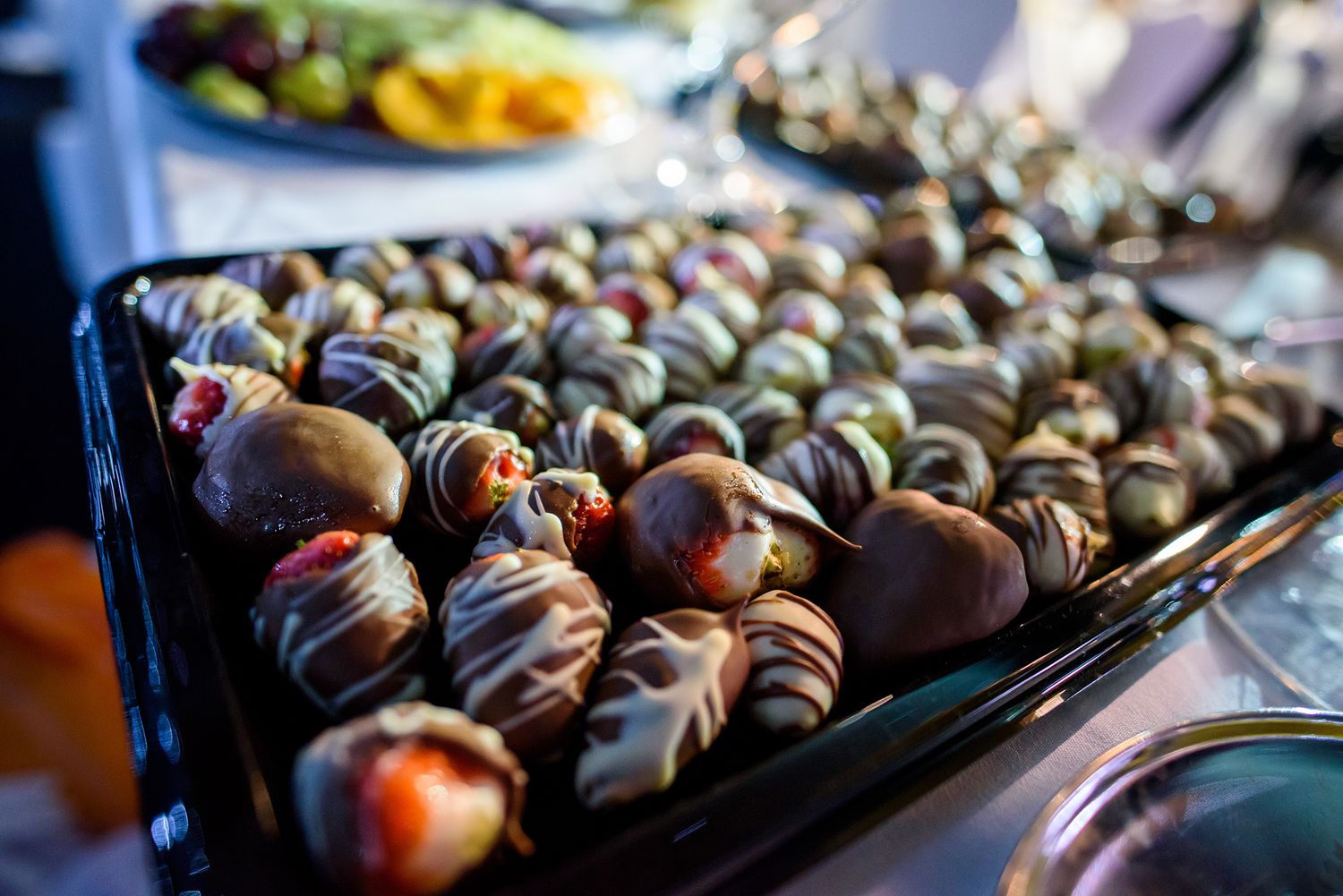 Beautifully plated appetizers arranged in rows on dark serving trays.