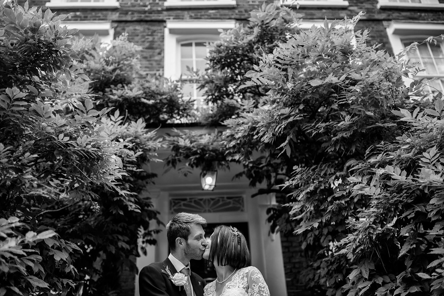 A romantic black and white moment captured between two people in front of an elegant building.