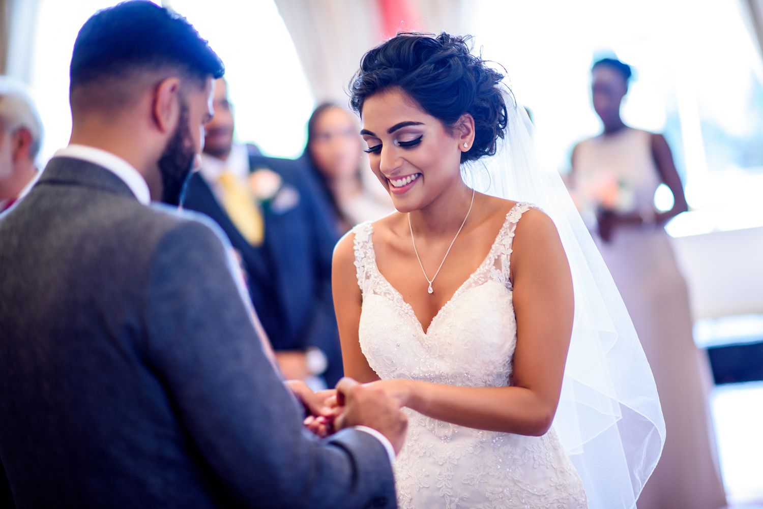 Beautiful bride in lace dress sharing joyful dance moment at reception.
