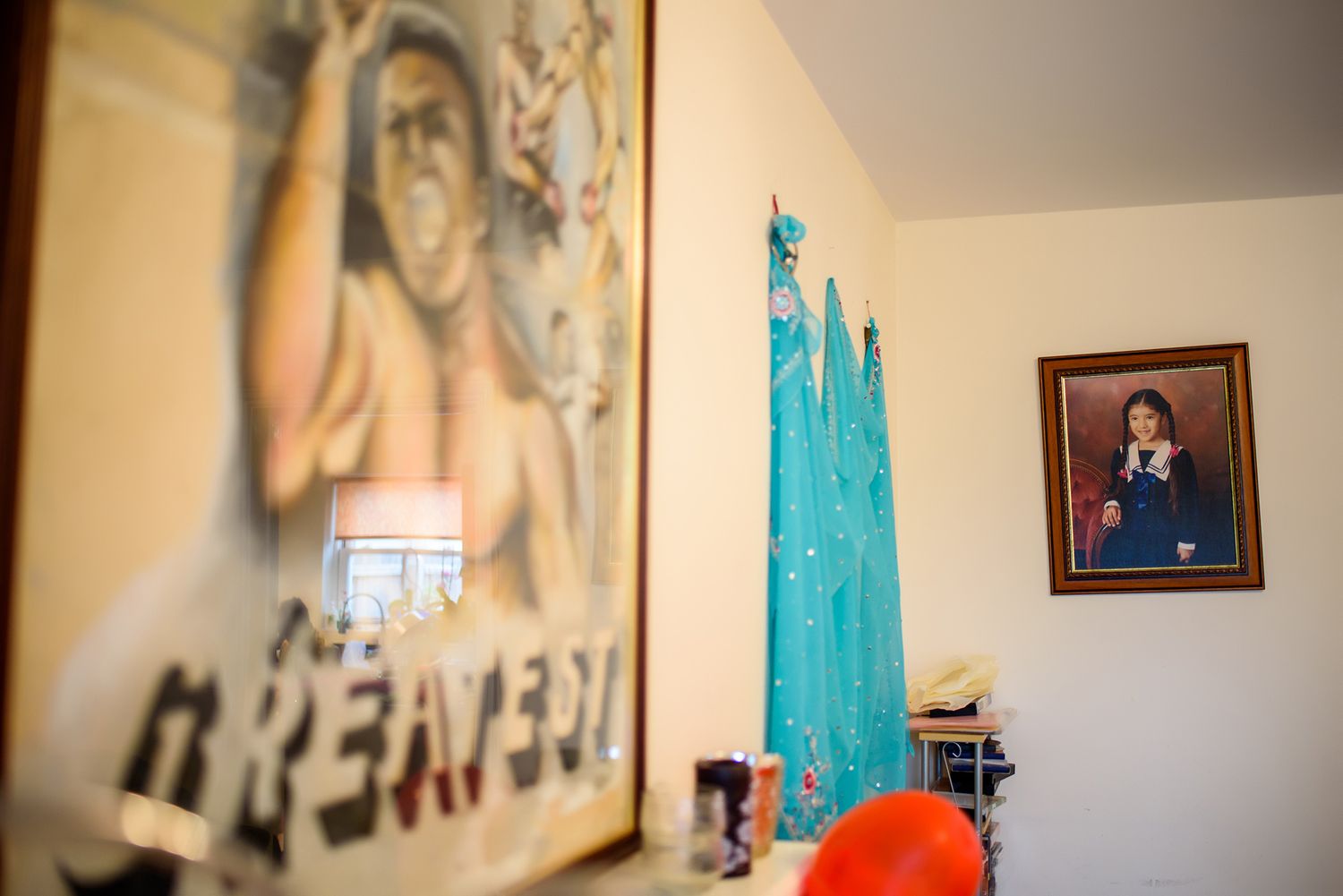 Room interior with framed artwork and teal curtains visible in soft focus.