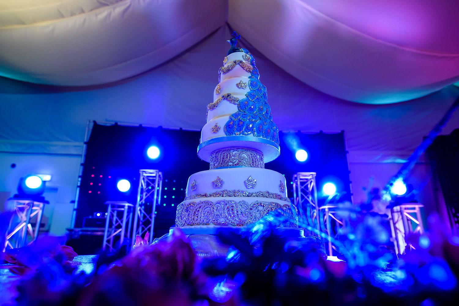 Wedding reception venue with dramatic purple and blue lighting and elegant white decor.