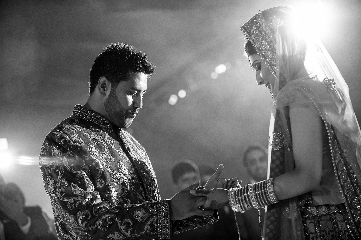 Black and white candid moment during traditional Indian wedding ceremony.
