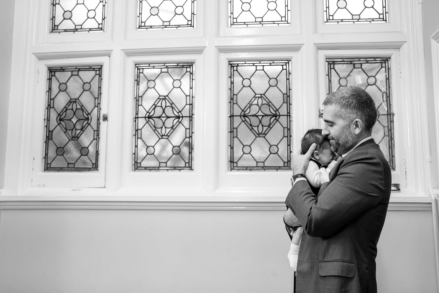 Decorative stained glass windows frame an elegant indoor wedding ceremony.