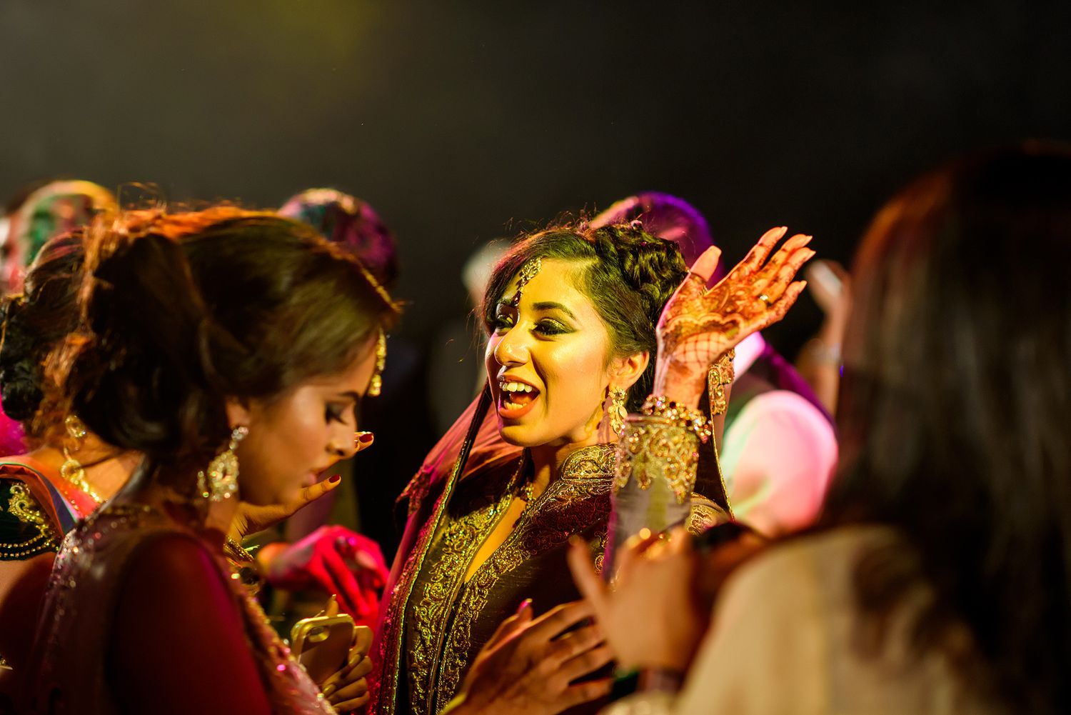 Traditional Indian wedding celebration with guests celebrating joyfully with turmeric powder during Haldi ceremony.