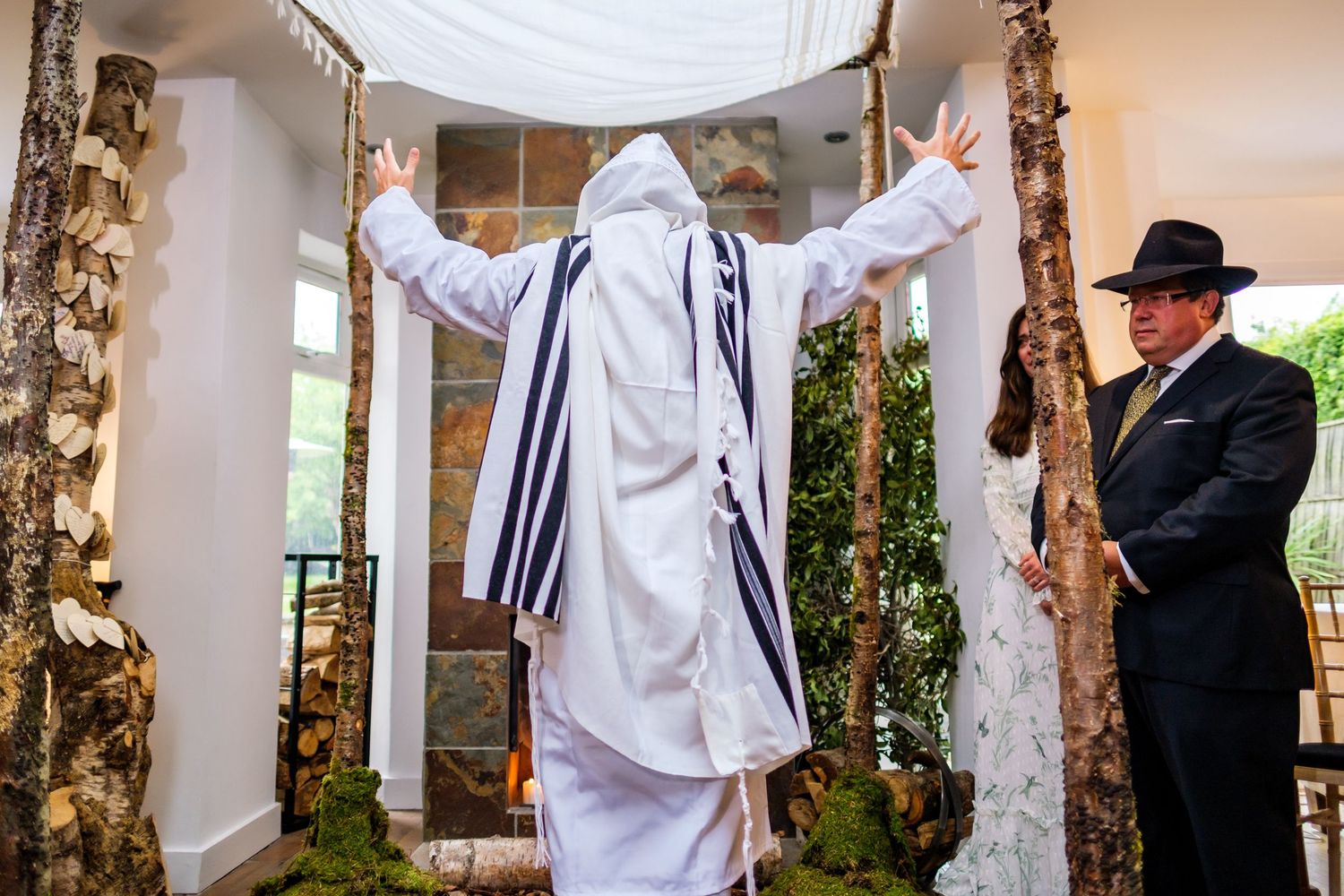 A Jewish wedding ceremony taking place under a covered outdoor space with decorative columns.