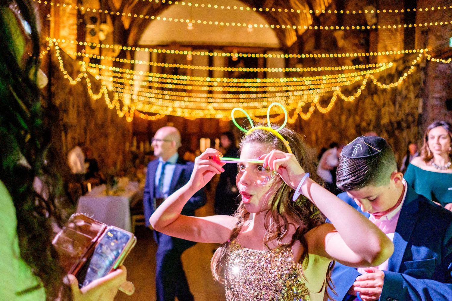 Evening wedding reception with string lights creating a magical dance floor atmosphere.