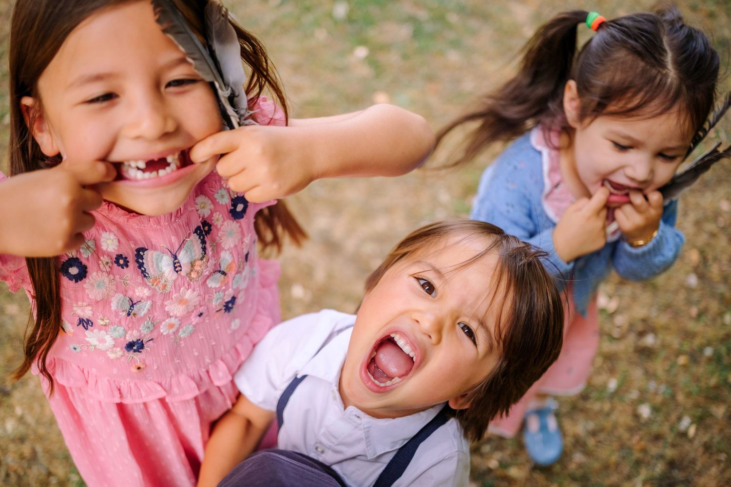 Children playing outdoors together show joyful expressions and natural interaction while having fun.