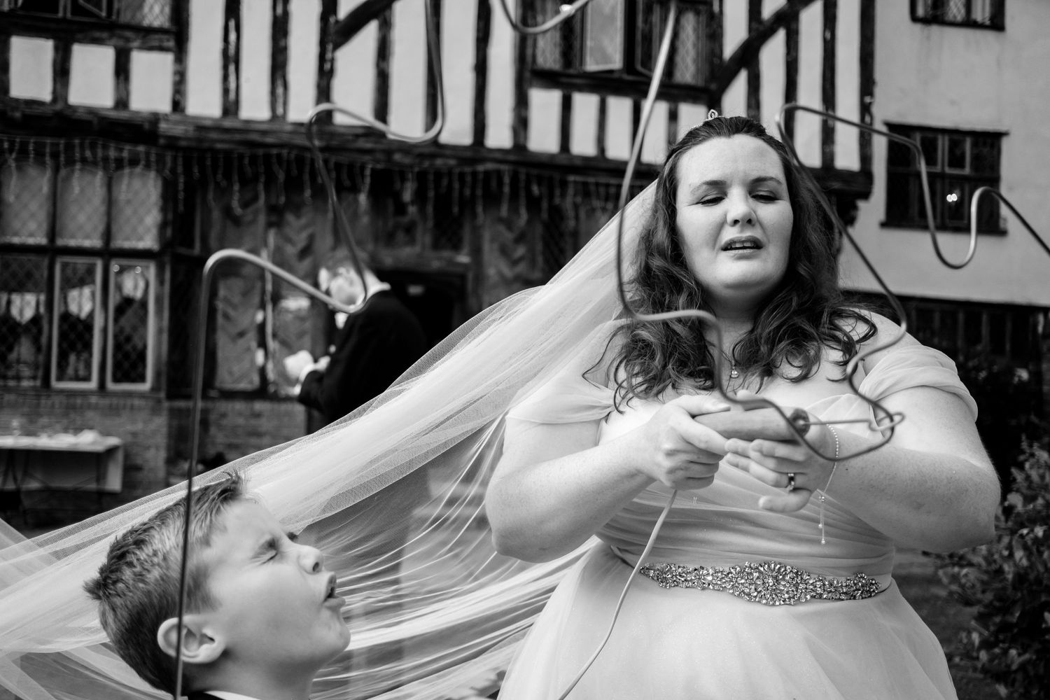Wedding party candid moments captured in black and white photography at an outdoor venue.
