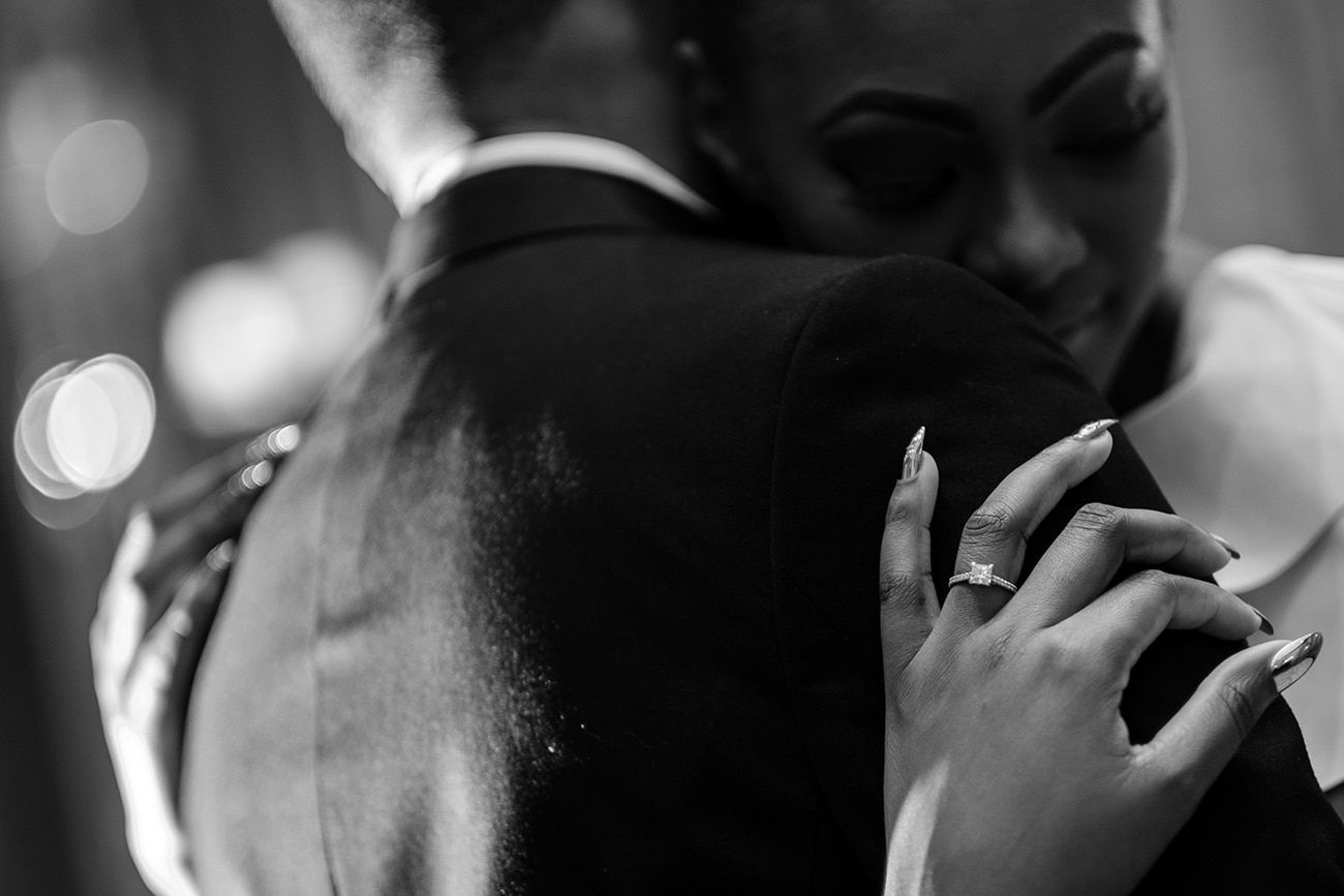 Intimate dance moment captured in dramatic black and white with bokeh lighting effects.