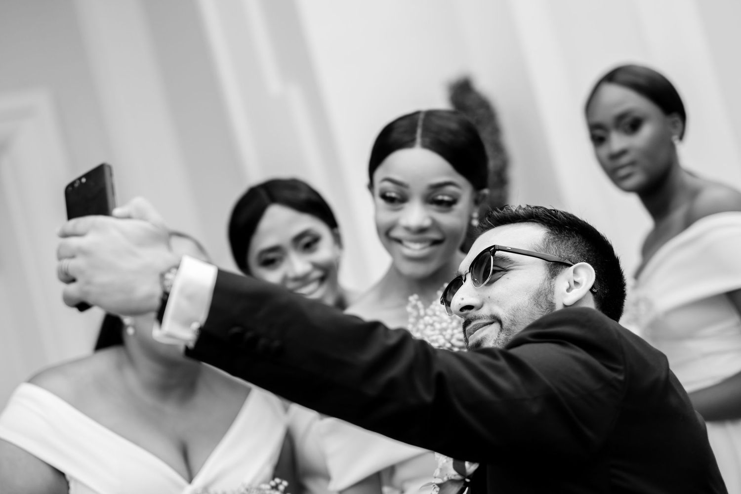 Black and white candid shots of wedding party members sharing joyful moments.