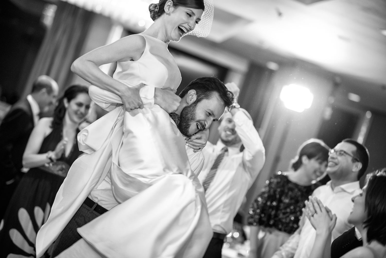 Black and white images of people dancing and enjoying themselves at a wedding celebration.