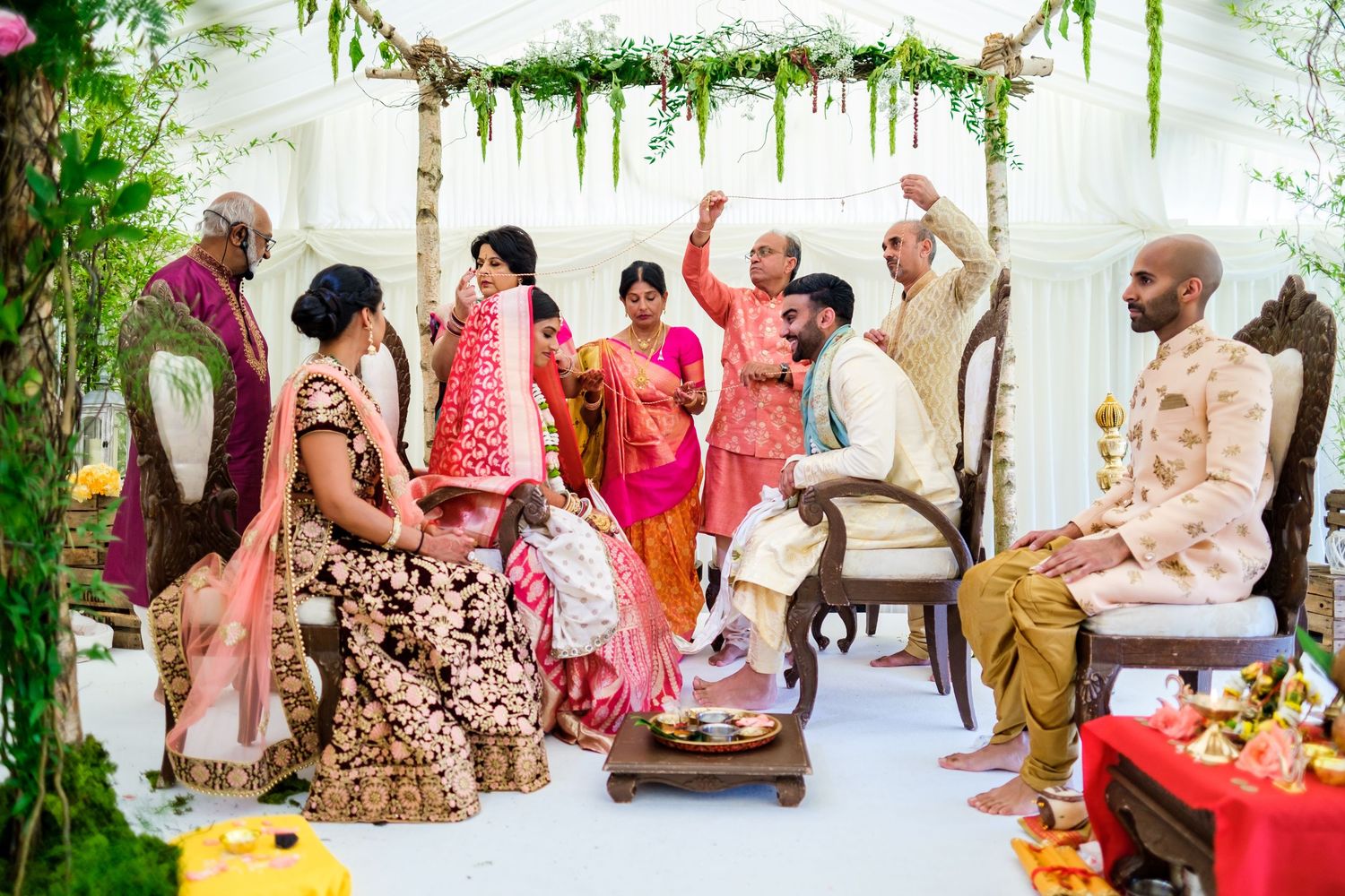 Elegant outdoor wedding ceremony setup with floral decorations and white draping.