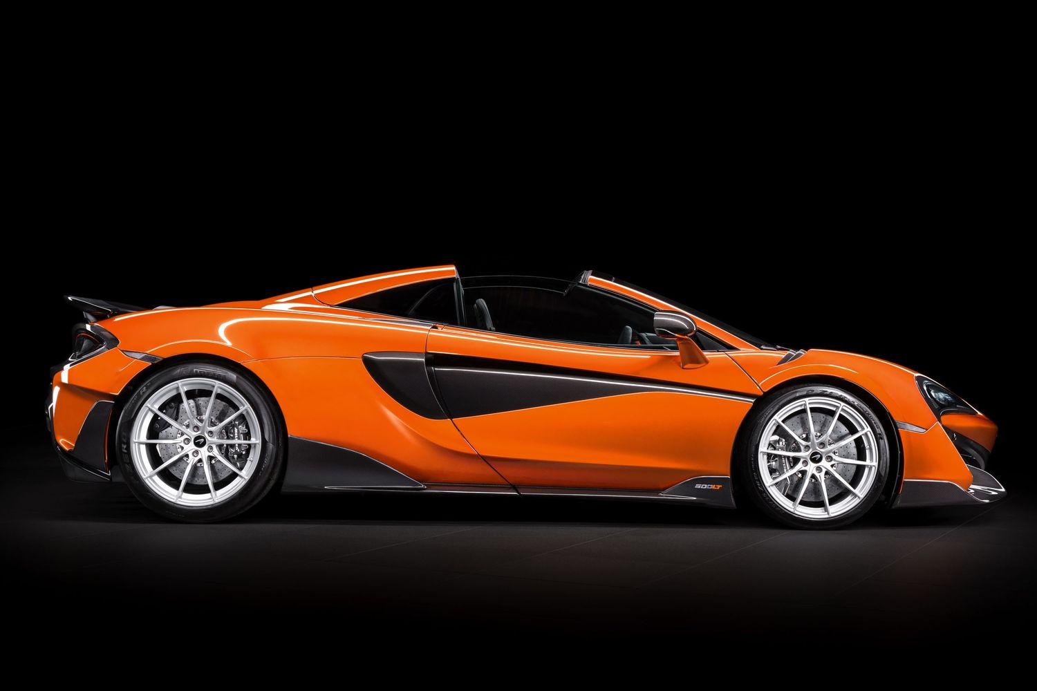 Sleek orange McLaren sports car shown from multiple side angles against black background.