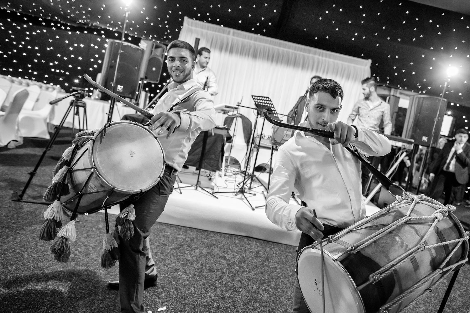 Live band performing at wedding reception with instruments and lighting equipment.