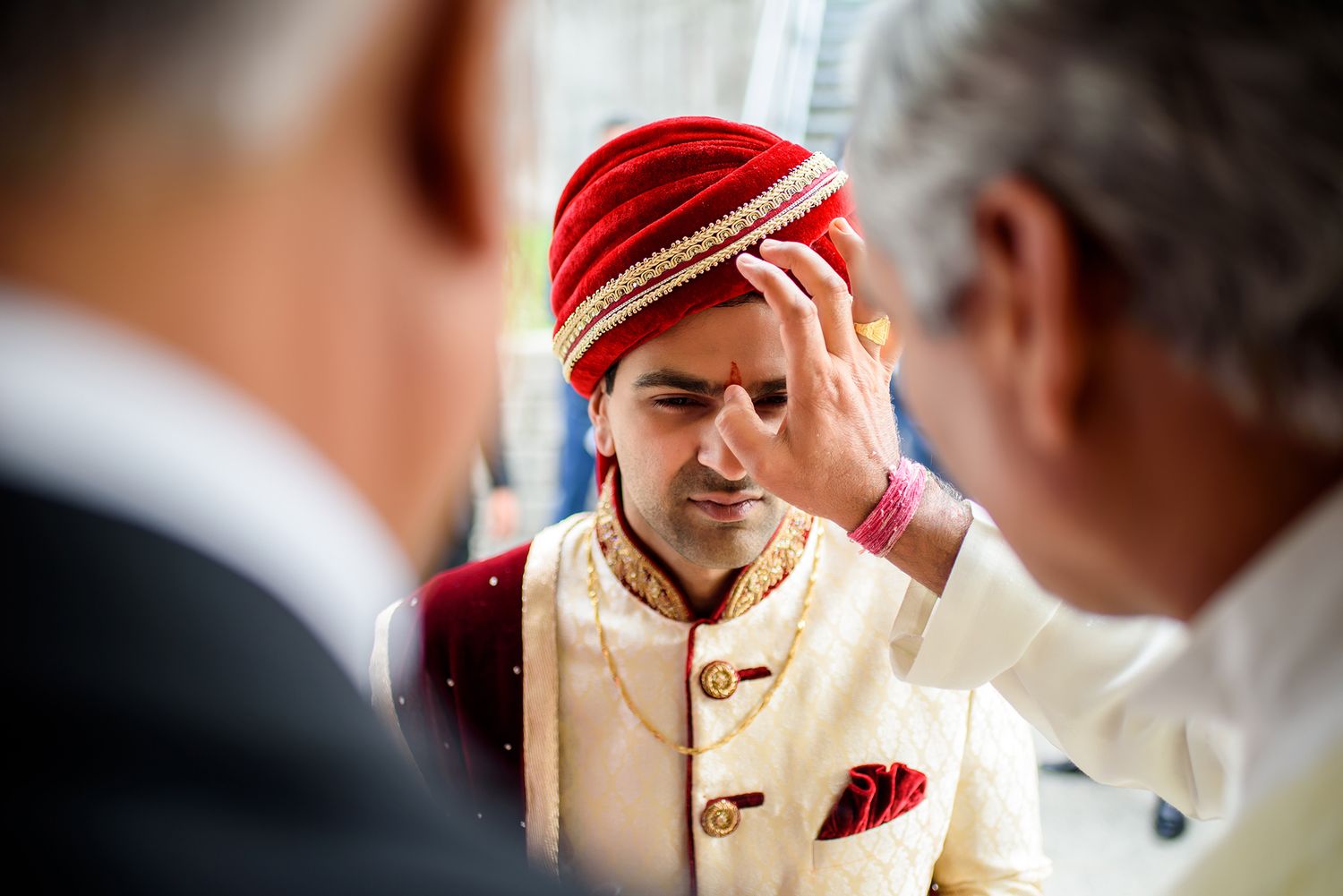 Multiple views of groom in red turban and cream sherwani during traditional wedding ceremony.