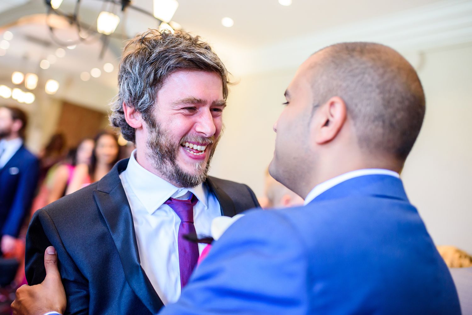 Candid laughter and joy shared between guests at an elegant wedding reception.