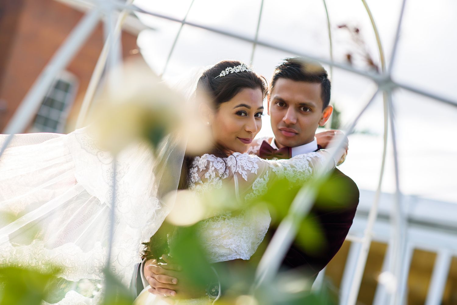 Wedding ceremony under white tent with floral decorations.