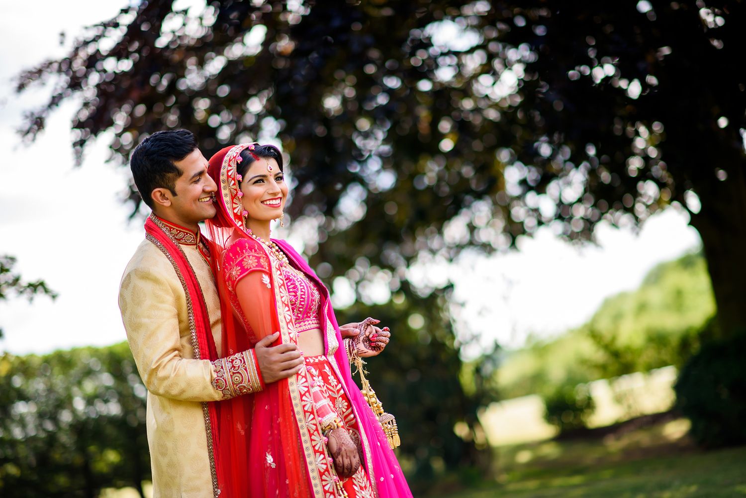 Romantic outdoor wedding portrait session in a park with natural bokeh lighting effects.