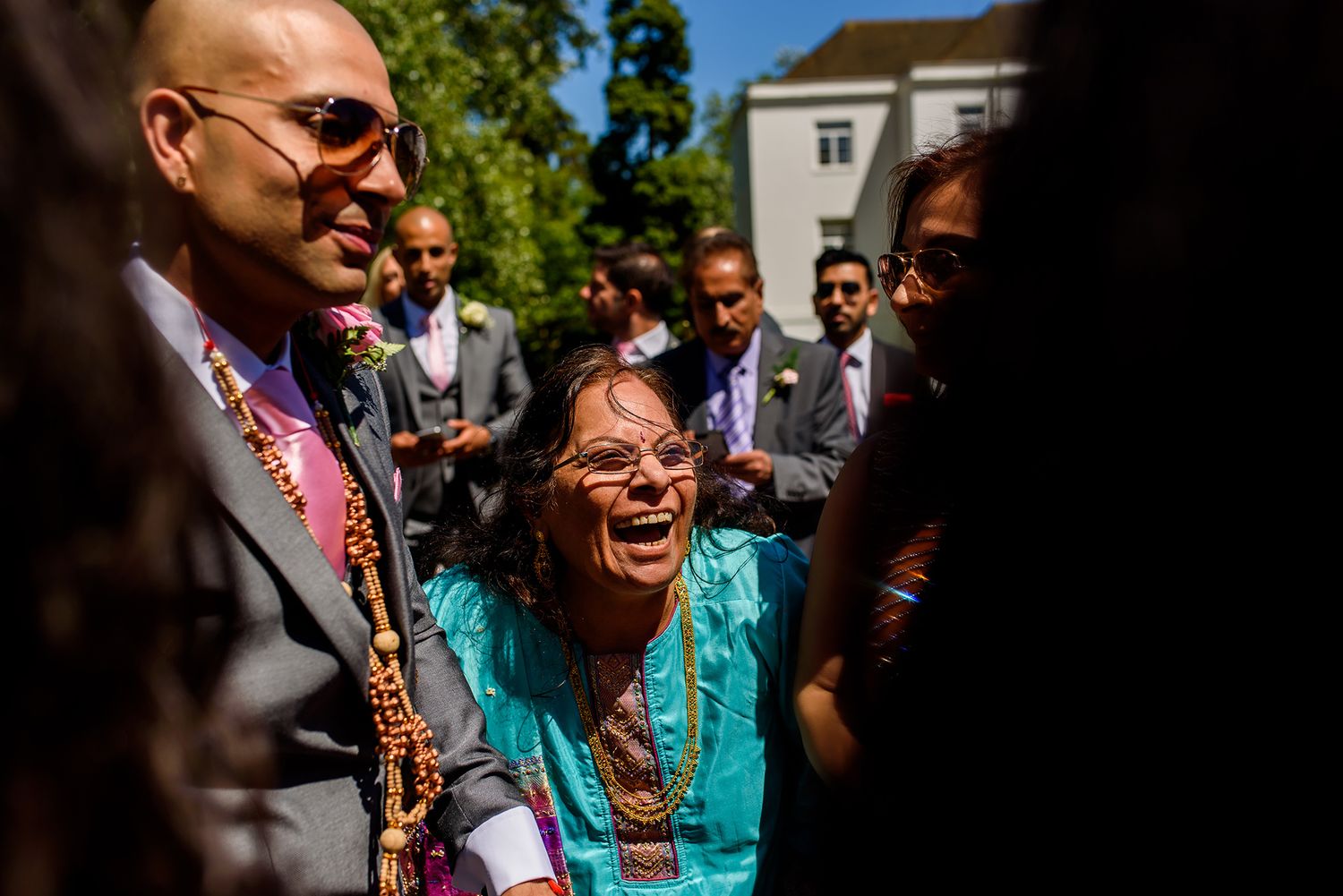 Wedding guests in colorful attire enjoying an outdoor celebration.