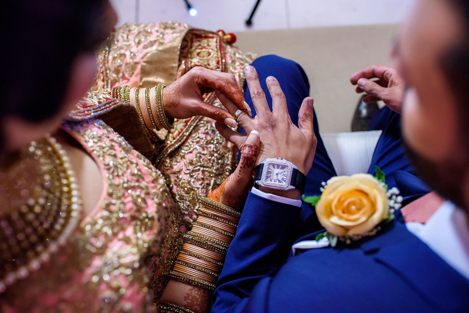 Gold bangles and jewelry details at an Indian wedding ceremony.