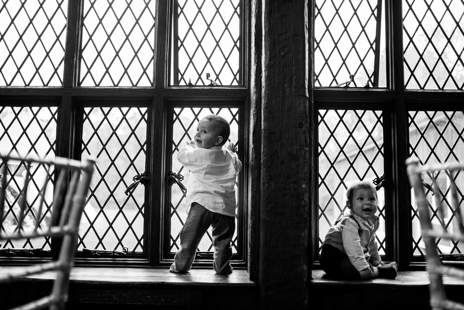 Diamond-patterned window frames silhouette guests at an indoor gathering.