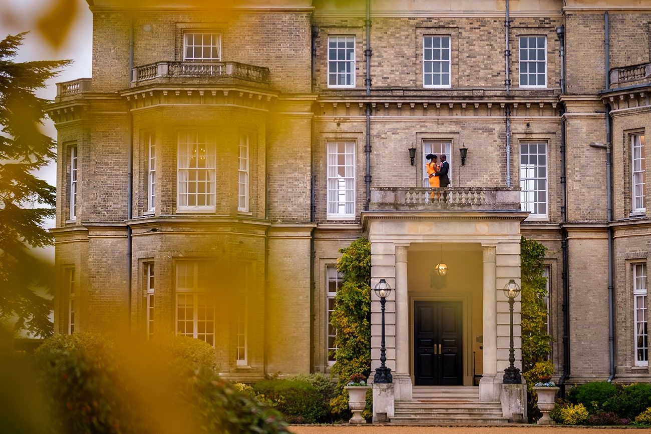 Majestic stone mansion exterior with ornate architectural details and classic windows captured in warm sunlight.