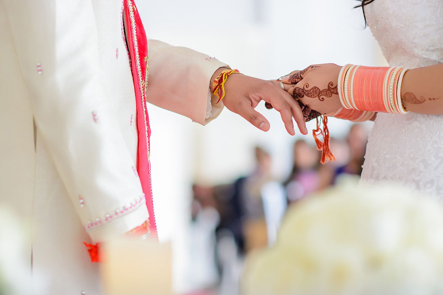 Close-up details of traditional Indian wedding accessories and decorations in red and white.